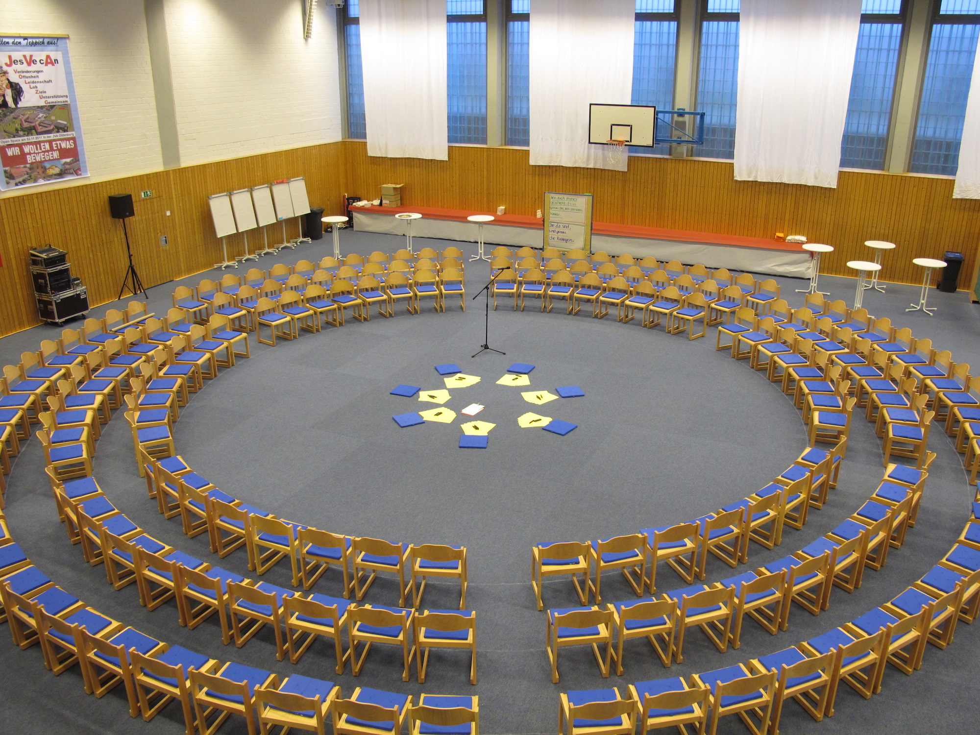 Konzentrischer Stuhlkreis mit Mikrofon und Themenkarten als Aufbau für einen Open-Space-Workshop