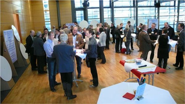 Teilnehmende im Austausch an Stehtischen bei einem World-Café-Workshop